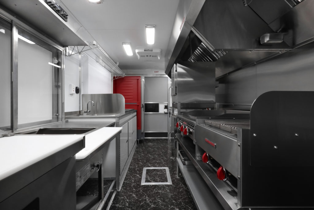 mane fare food truck interior with grill, griddle, sink, warming cabinet, sandwich prep table and other kitchen equipment