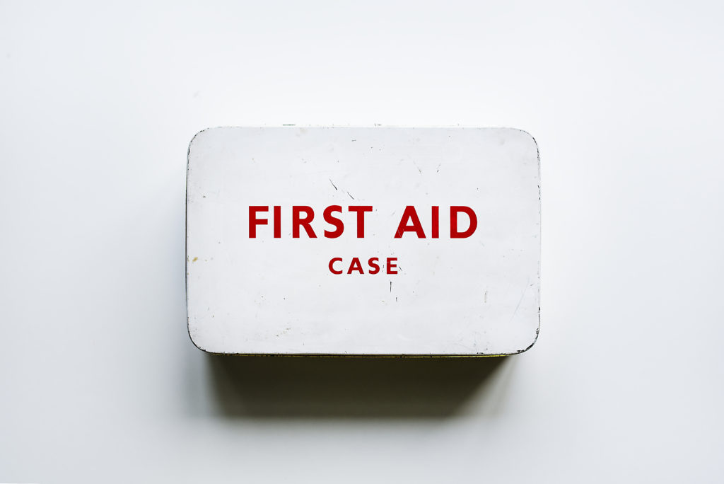 photo of an old white metal box that says First Aid Case in red letters