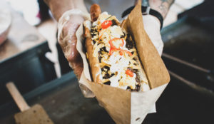 food truck vendor holding a hot dog